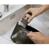 Joseph Joseph Palm Scrub Grey indų plovimo šepetys su integruotu muilo dozatoriumi