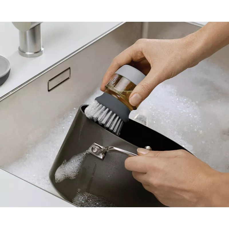 Joseph Joseph Palm Scrub Grey indų plovimo šepetys su integruotu muilo dozatoriumi